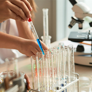Test tubes sit in front of a microscope.